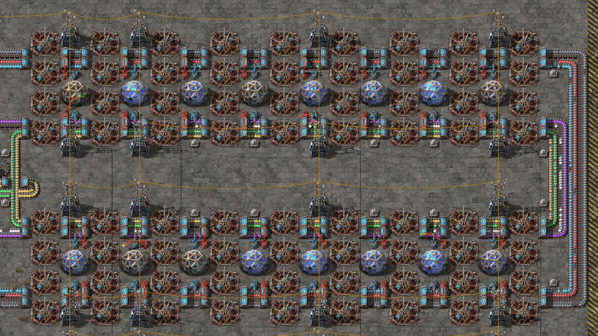 Bloco de laboratórios de Factorio, alimentados por tapetes com science packs de várias cores